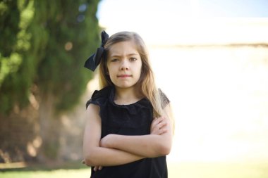 Siyah elbiseli, şık bir genç kızın yalnız portresi. Ağzını ısırıyor. Endişeli ve korkmuş görünüyor..