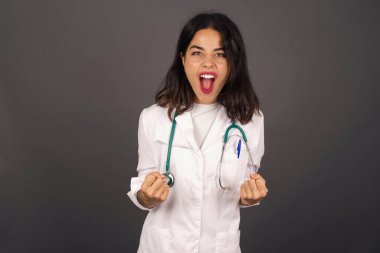 Güçlü ve kararlı genç doktorun portresi. Sıradan giysiler içinde, kollarını kaldırarak, yumruklarını sıkarak, sevinçle ve heyecanla golü haykırarak. Zafer, başarı ve başarı kavramı.