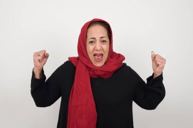 Güçlü, başarılı, kararlı, kollarını kaldıran, yumruklarını sıkan, sevinç ve heyecanla haykıran Müslüman kadının belini kaldırın. Zafer, başarı ve başarı kavramı.