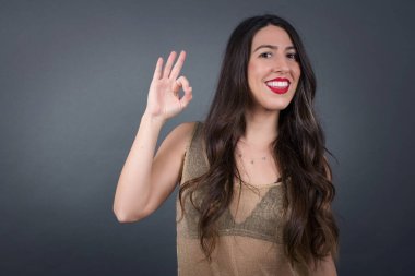 Gri arka planda iyi görünen güzel kadın.  