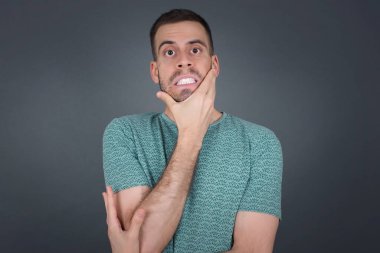 Endişe - yakışıklı beyaz bir adamın kavramsal görüntüsüdür. Ağzını elleriyle kapatır ve içeride durur. Bir şeyden ya da birinin çivi yemesinden korktun mu?