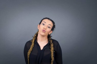 Hoş görünümlü genç bir bayan, dudaklarını öpecek gibi tutuyor, güler yüzlü, suratsız. Dışarıda dikiliyorum. Güzellik konsepti.