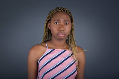 Gri arka planda acı ve depresyon çeken ve gözyaşı döken üzgün Afrikalı Amerikalı bir kadının güzel yüzü.