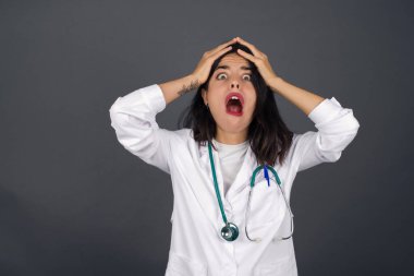 Korkunç, stres, şok. Kafasını tokalaştıran genç, duygusal, deli doktor kadın portresi. İnsani duygular, yüz ifadesi kavramı.