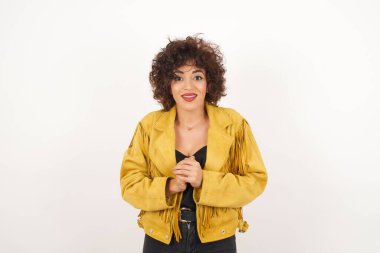 Vay canına. Süet ceketli güzel bir kadın. Gri stüdyo arka planında izole edilmiş yarım boy ön portre. Genç, duygusal, şaşkın bir kadın, ağzı açık duruyor. İnsani duygular, yüz ifadesi kavramı. Moda renkleri.