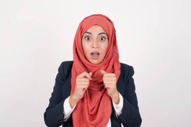 İnsan yüzü ifadeleri ve duyguları. Güzel Müslüman bir kadının portresi siyah ceket giyer ve tesettüre benzer bir panikle ellerini yüzüne yaklaştırır ve ağzını sonuna kadar açar. Umutsuzluk ve şok içindeki bir kadın