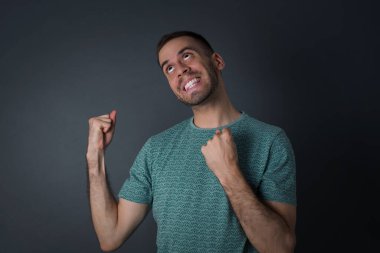 Yakışıklı bir adamın portresi mutlu ve heyecanlı kazanan bir jest. Başarılı ve zaferi kutlayan, muzaffer.