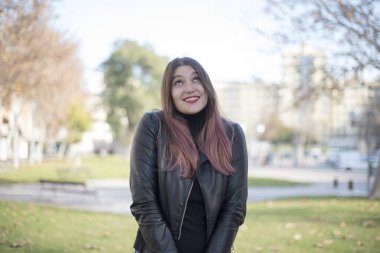 Genç ve güzel bir kadın parka bakıyor.