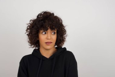 Hayalperest, genç bir kadın, düşünceli bir yüz ifadesi var, elleri havada, dudaklarını ısırıyor, gri duvara karşı hoş bir poz düşünüyor..