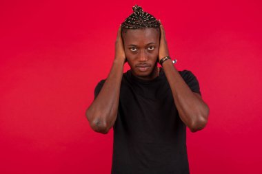 Elleriyle kulaklarını tıkayan Afrikalı Amerikalı adam hard rock veya yüksek sesle müzik dinlemek istemiyor. Avrupalı adam gürültüyü görmezden geliyor ya da elleri kulaklarını tıkayarak sokakta yüksek seslerden kaçınıyor..