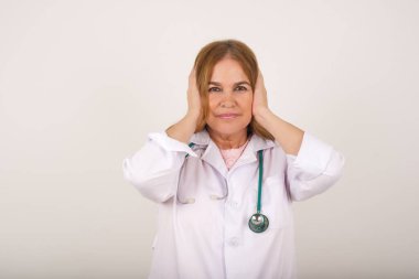 Elleriyle kulaklarını tıkayan doktor kadın hard rock veya yüksek sesle müzik dinlemek istemiyor.. 