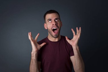 Çığlık, nefret, öfke. Stüdyonun arka planında ağlayan duygusal sinirli adam. Duygusal, genç yüz. 