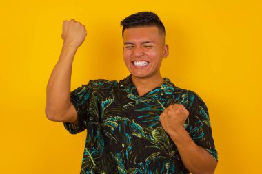 Yakışıklı İspanyol adamın mutlu ve heyecanlı portresi. Kazanan jestler. Başarılı ve zaferi kutlayan, muzaffer.