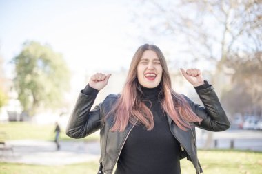 Genç ve güzel bir kadın parkta bağırıyor.