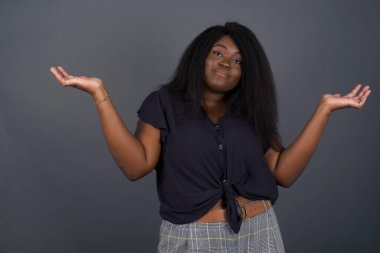 Kafası karışık ve cahil, kolları açık, omuzlarını silkip 