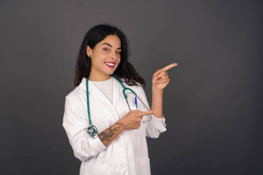 Çekici genç doktor, ağzı açık neşeli ve şaşkın bir ifadeyle içeride inanılmaz bir şey gösteriyor. Reklam kavramı.