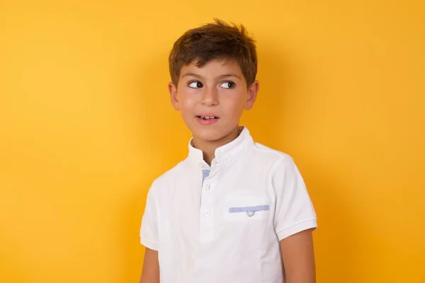 Schattig Jongen Kijken Weg Tegen Gele Muur — Stockfoto