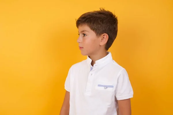 黄色の壁に目を背けてかわいい男の子 — ストック写真