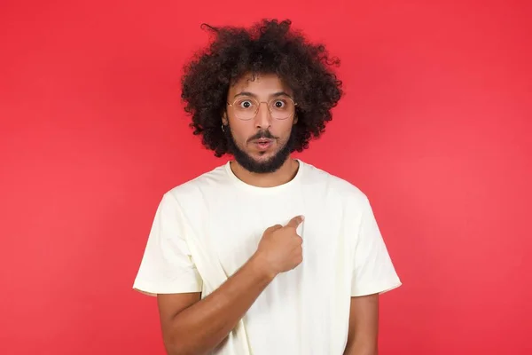 Junger Mann Mit Afro Haaren Zeigt Auf Rote Wand — Stockfoto