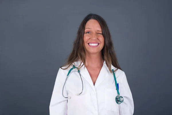 Linda Joven Doctora Con Cabello Largo Vistiendo Uniforme Médico Parpadeando — Foto de Stock