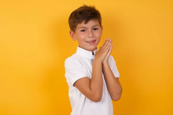 Söt Pojke Med Handflator Tillsammans Mot Gul Vägg — Stockfoto