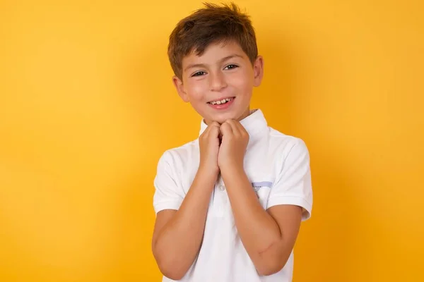 Lindo Chico Con Las Manos Juntas Contra Pared Amarilla —  Fotos de Stock