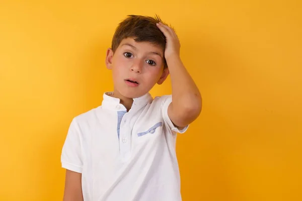 黄色の壁に対してかわいい混乱した少年 — ストック写真