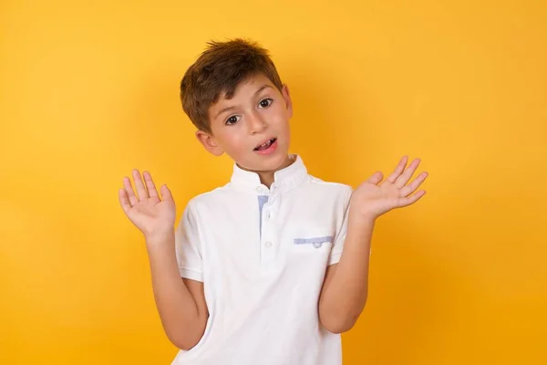 Schattig Jongen Met Open Handpalmen Tegen Gele Muur — Stockfoto