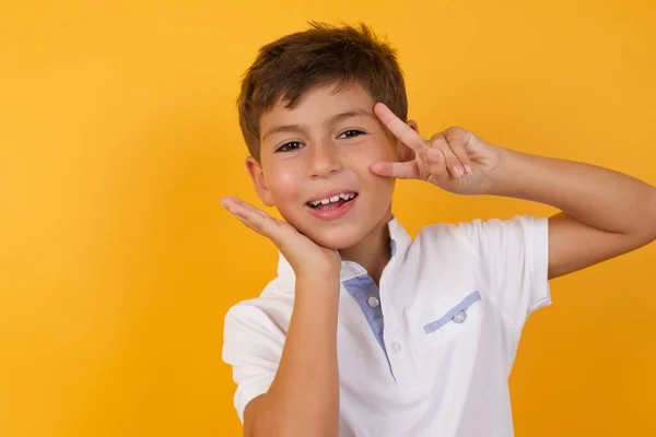 Bonito Menino Gestos Contra Amarelo Parede — Fotografia de Stock