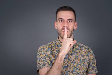 Sırrımı söyleme ya da yüksek sesle konuşma, lütfen! Duygusal olarak şaşırmış bir öğrenci sessiz olur, sessiz olur musun diye sorar. Sırrını açıklamaktan korkar ve gri stüdyo duvarına karşı durur..