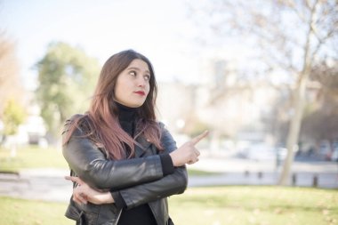 Genç ve güzel bir kadın parkı işaret ediyor.