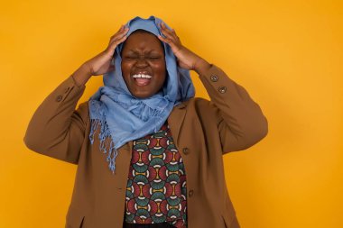 Şok olmuş Afro-Amerikan Müslüman kadın şık giyinmiş kafasının üstünde el ele tutuşmuş ve umutsuzluk ve hüsran içinde çığlık atıyordu. Uçağa geç kaldığında gözleri dehşet içindeydi, ağzı açıktı.