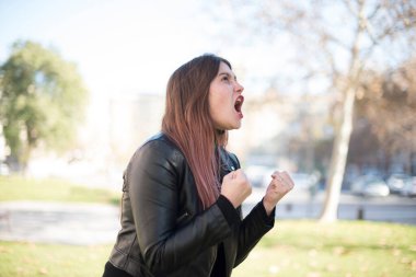 Genç ve güzel bir kadın parkta kutlama yapıyor.  