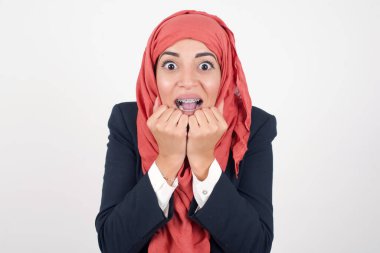 Stüdyo çekimlerinde, güzel Müslüman kadın siyah ceket giyer ve tesettüre başörtüsü el ele tutuşur, keyifli bir ruh halinde olur, ertesi günün arkadaş fikrini sever, gri duvarda izole olur. Pozitif duygular.