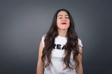 Gri arka planda gözleri kapalı güzel bir kadın..  