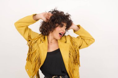 Güven ve cinsel ilişki konsepti. Çekici bir genç kızın portresi, el ele tutuşurken kendinden emin bir ifadeyle geniş bir gülümseme. Gri arkaplanda duruyor.