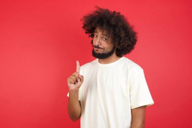 Kızıl duvara dayanmış afro saçlı genç adam.   