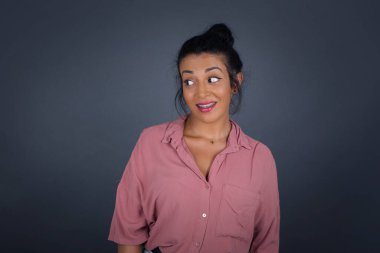 Hayalperest, genç bir kadın, düşünceli bir yüz ifadesi var, elleri havada, dudaklarını ısırıyor, gri duvara karşı hoş bir poz düşünüyor..