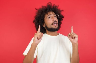 Kızıl duvara dayanmış afro saçlı genç adam.   