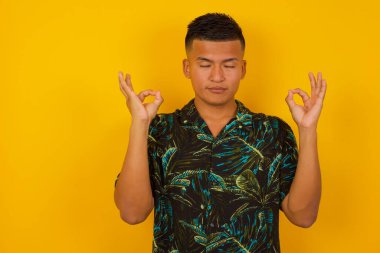 Meditasyon, din ve ruhani uygulamalar. Yakışıklı İspanyol adam gözlerini kapalı tutuyor, parmaklarını Mudra jestinde tutuyor..