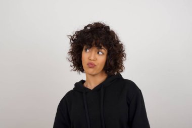 Hoş görünümlü genç bir kız öğrenci, düşünceli bir şekilde kenara bakıyor, üniversiteden sonra eylemler planlıyor, ne yapacağını hayal ediyor. Zeki kadın yeni projesini düşünüyor. Boşluğu griye kopyala.