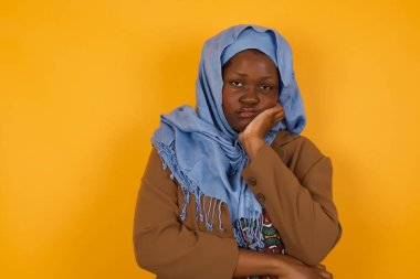 Hüzünlü, genç, üzgün, Asyalı, Afrikalı, Amerikalı Müslüman kadın üzgün, üzgün, üzgün, üzgün, üzgün, üzgün, karamsar, karamsar, soluk benizli bakışlar atıyor.