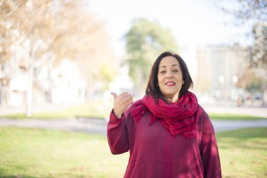 Güzel orta yaşlı Arap kadın parkı işaret ediyor.  