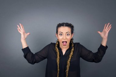 Neşeli kadın ellerini kaldırıyor, mutlulukla dolu gözleriyle büyük başarılarını kutluyor..