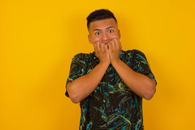 Anksiyete - kavramsal bir resim İspanyol bir adam ağzını ellerle kapatıyor ve kapalı bir yerde duruyor. Bir şeyden ya da birinden tırnak yemekten korktun mu?.