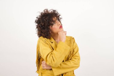 Düşünceli kadın portresi elini çenesinin altında tutuyor, bir şey hatırlamaya çalışıyor ya da ilgi çekici bir şey dinliyor, sıradan giyiniyor, içeride poz veriyor. Gençlik kavramı.