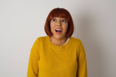 İnsanlar ve ani tepki kavramı. Şaşırmış öğrenci, omuz silkiyor, yan bakıyor, arkadaşlarıyla yeni planları için mutlu ve heyecanlı. Gri duvarda izole edilmiş..