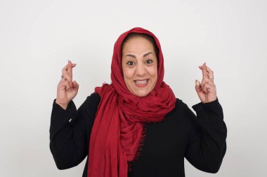 Kazanmak zorundayım. Neşeli olgun Müslüman kadın dişlerini sıkar, parmaklarını çaprazlar, arzu edilir dilekler diler, günlük kıyafetler giyer, iyi haberleri bekler, gri duvarın üzerinde durur.