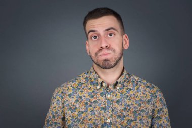 Komik yüzlü, yanak şişiren yakışıklı genç adam. Havayla şişmiş ağız, çılgın bir ifade..