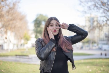 Parkta el kol hareketi yapan güzel bir kadın.